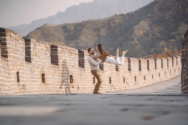 Belo jovem casal correndo e pulando na Grande Muralha da China . — Fotografia de Stock