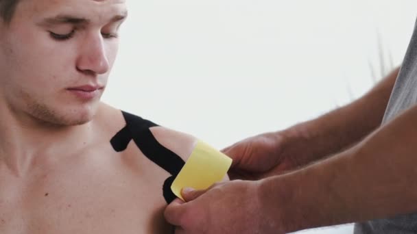 Osteópata haciendo cinesiología grabando en pacientes hombro en clínica — Vídeos de Stock