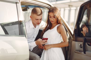 Güzel bir çift, bir yaz parkında bir arabanın yanında vakit geçirir.