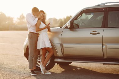 Güzel bir çift, bir yaz parkında bir arabanın yanında vakit geçirir.