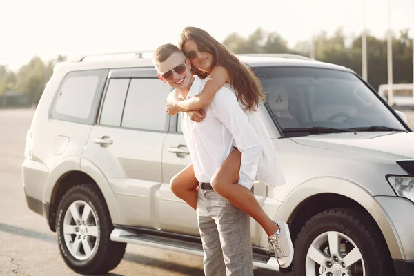 Belo casal passar o tempo em um parque de verão perto de um carro — Fotografia de Stock