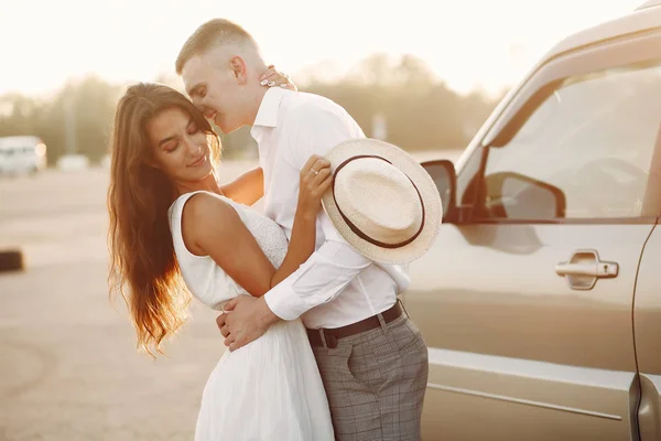 Vackra par tillbringar tid i en sommarpark nära en bil — Stockfoto