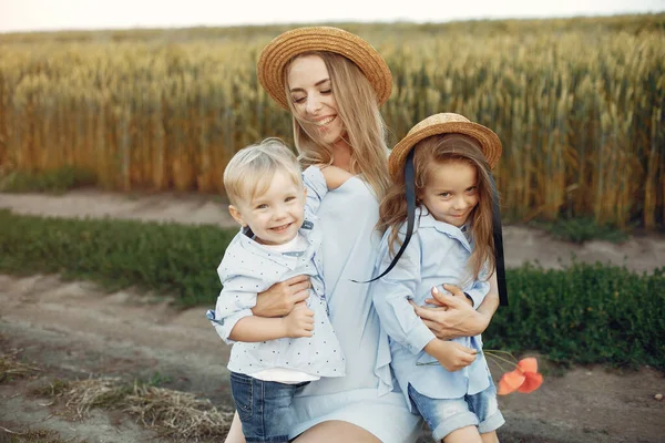 Mãe com crianças brincando em um campo de verão — Fotografia de Stock