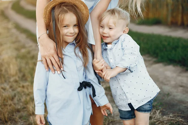 Matka z dziećmi bawiącymi się na letnim polu — Zdjęcie stockowe