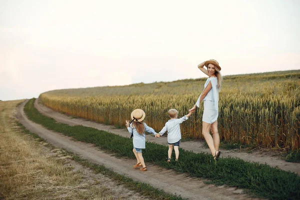 Mãe com crianças brincando em um campo de verão — Fotografia de Stock