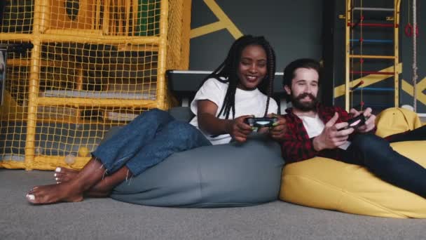 Vänner spelar spel på konsol med joysticks tillsammans inomhus — Stockvideo