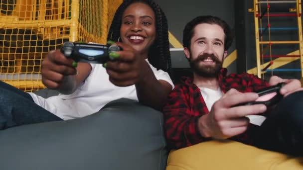 Amigos jugando juego en la consola con joysticks juntos en el interior — Vídeos de Stock