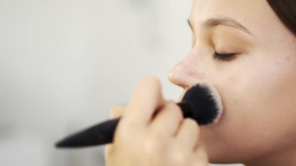 Close-up van het vrouwelijke gezicht tijdens het doen van make-up in de salon — Stockvideo