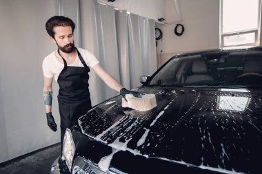 Garajda arabasını yıkayan adam
