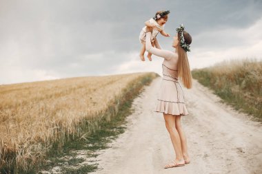 Anne ve kızı yaz tarlasında oynuyorlar.