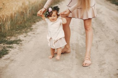 Anne ve kızı yaz tarlasında oynuyorlar.