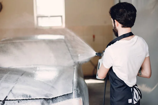 Homem lavando seu carro em uma garagem — Fotografia de Stock