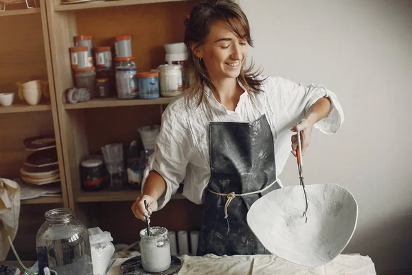 Een jonge vrouw maakt gerechten in een aardewerk — Stockfoto