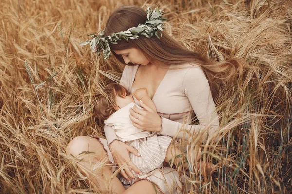 Elegante madre con carina figlioletta in un campo — Foto Stock