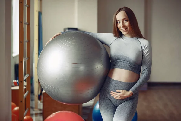 Mujer embarazada entrenando en un gimnasio —  Fotos de Stock