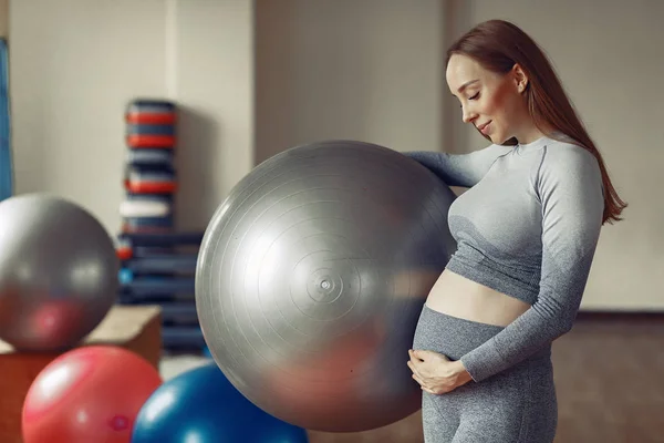 Femeie gravidă de formare într-o sală de gimnastică — Fotografie, imagine de stoc