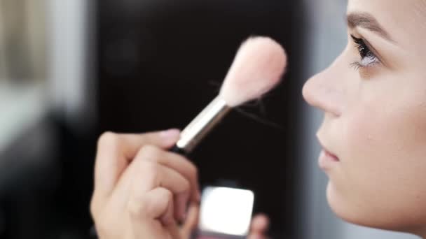 Primer plano de la cara de la joven dama haciendo maquillaje en el salón — Vídeos de Stock