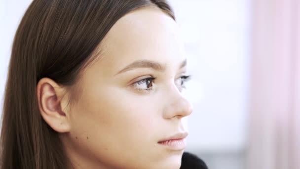 Primer plano de la cara de la joven dama haciendo maquillaje en el salón — Vídeo de stock