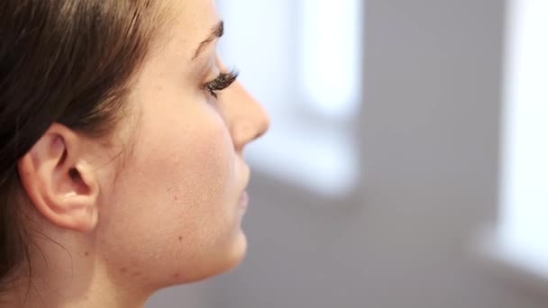 Обрезанный вид лица девушки с макияжем в салоне красоты — стоковое видео