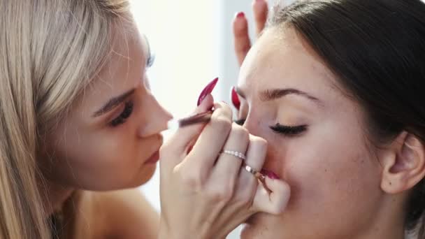 Close-up van make-up kunstenaar doet make-up voor de klant in salon — Stockvideo