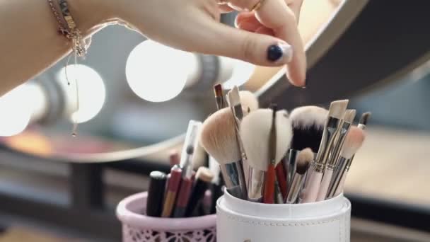 Cropped view of cosmetics brushes and womans hand in salon — Stock Video