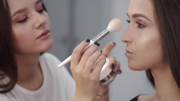 Maquillaje artista haciendo maquillaje para morena cliente en el salón — Vídeos de Stock