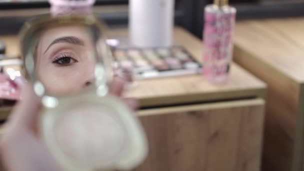 Client looking at result of makeup in mirror in beauty salon — 비디오