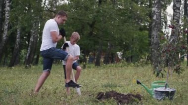 The family of father and son are making a place to plant a tree