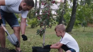 The father and his son are taking the soil off a pot
