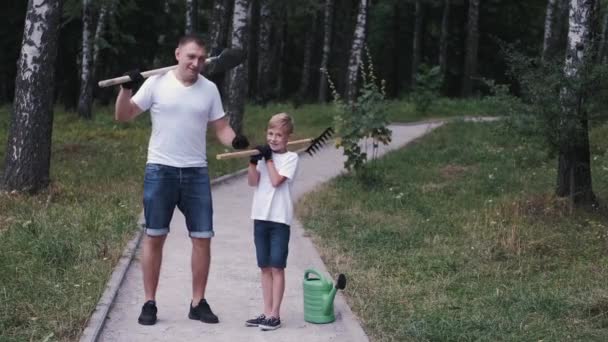 Happy gardeners father and his son are standing with the tools — 비디오