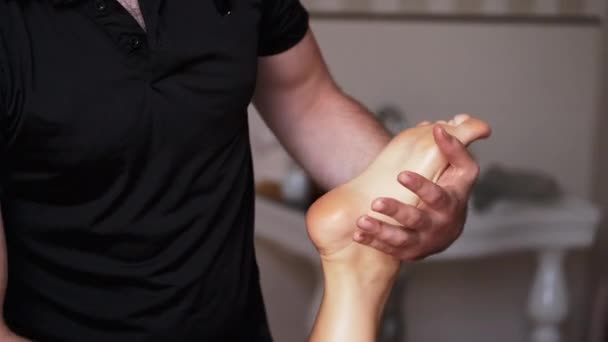Массер масажує ноги дорослої жінки в спа. — стокове відео