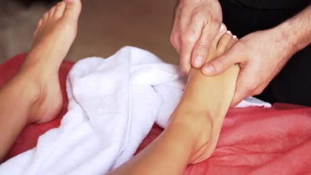 Massagista fazendo massagem nos pés para mulher adulta no spa — Vídeo de Stock