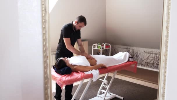 Терапевт делает массаж живота брюнетке — стоковое видео
