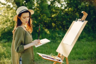 Tarlada resim yapan zarif ve güzel bir kız.