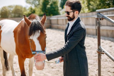 Çiftlikte duran eli olan adam.