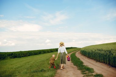 Güzel anne ve küçük oğlu yaz tarlasında