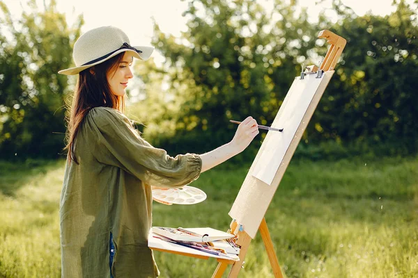 Elegante e bella ragazza pittura in un campo — Foto Stock