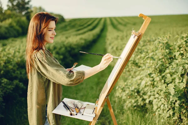 Elegante e bella ragazza pittura in un campo — Foto Stock