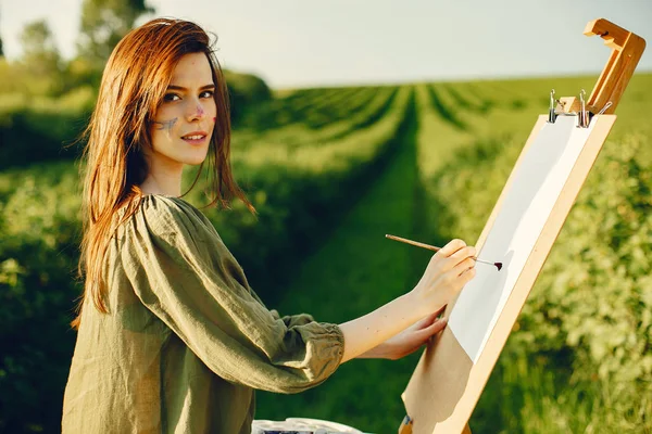 Elegant and beautiful girl painting in a field — 스톡 사진