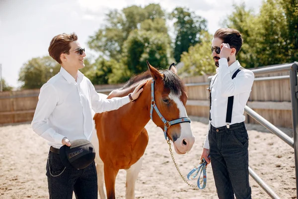 Handsme mannen staan in een ranch — Stockfoto