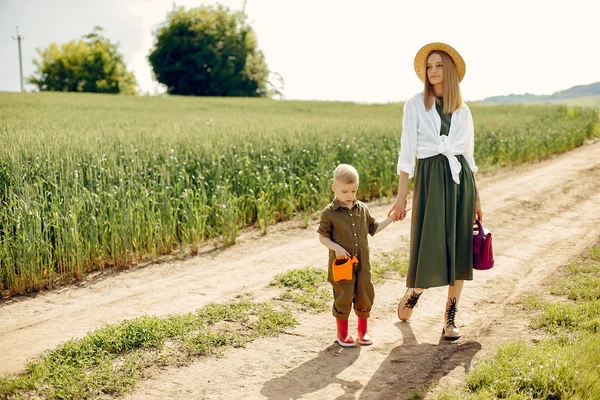 Mãe bonita com filho pequeno em um campo de verão — Fotografia de Stock
