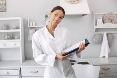 Beautiful doctor in a kitchen with a vegetables