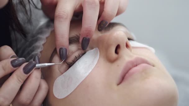 Um técnico de cílios está enrolando as pestanas dos olhos com uma ferramenta — Vídeo de Stock