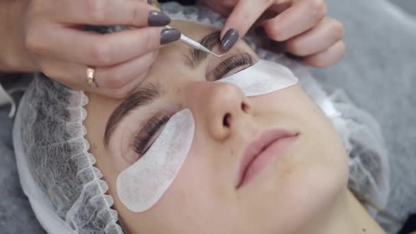 Der Wimpernmeister fixiert die Wimpern auf einem Liftpad — Stockvideo