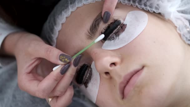 The lash artist is dying the lashes after lamination — Stock Video