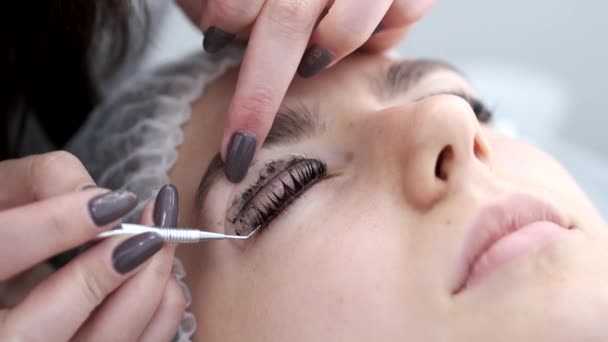 Egy szempillaművész most fejezi be a szempilla laminálásának eljárását. — Stock videók