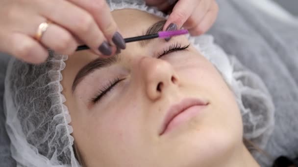 Der Wimpernmacher bürstet die Wimpern. — Stockvideo