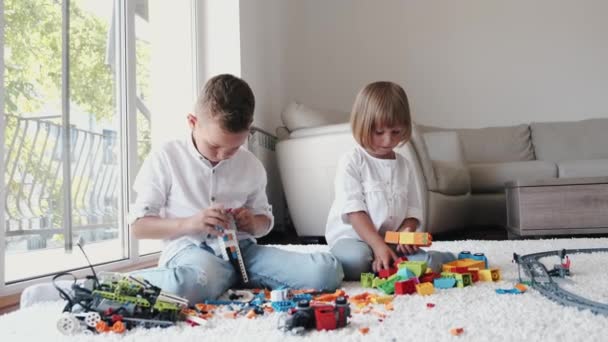 Irmão e irmã brincando com lego no chão em casa — Vídeo de Stock