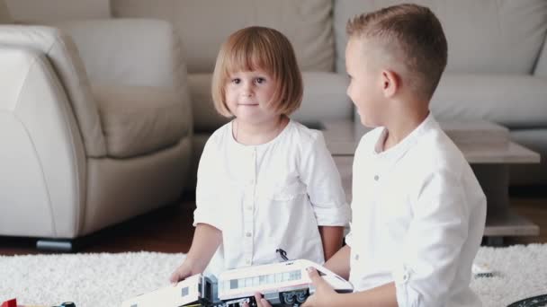 Twee kinderen spelen met speelgoed spoorweg samen thuis — Stockvideo