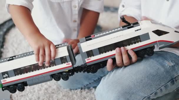 Vista recortada de la celebración y el juego con trenes de juguete en casa — Vídeos de Stock